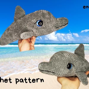 May include: A gray crocheted dolphin plush toy with large blue and black eyes. The text "eng/pdf" appears in the top right corner, and the text "Crochet pattern" is printed in black at the bottom left of the image.