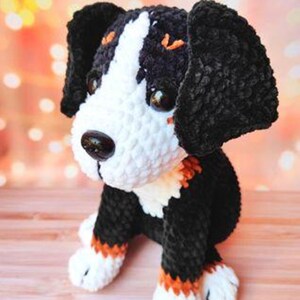 K&ouml;nnte beinhalten: Ein geh&auml;keltes Pl&uuml;schtier eines Berner Sennenhunds mit schwarzem, wei&szlig;em und braunem Fell. Das Spielzeug hat gro&szlig;e, schwarze Augen und eine kleine, schwarze Nase.
