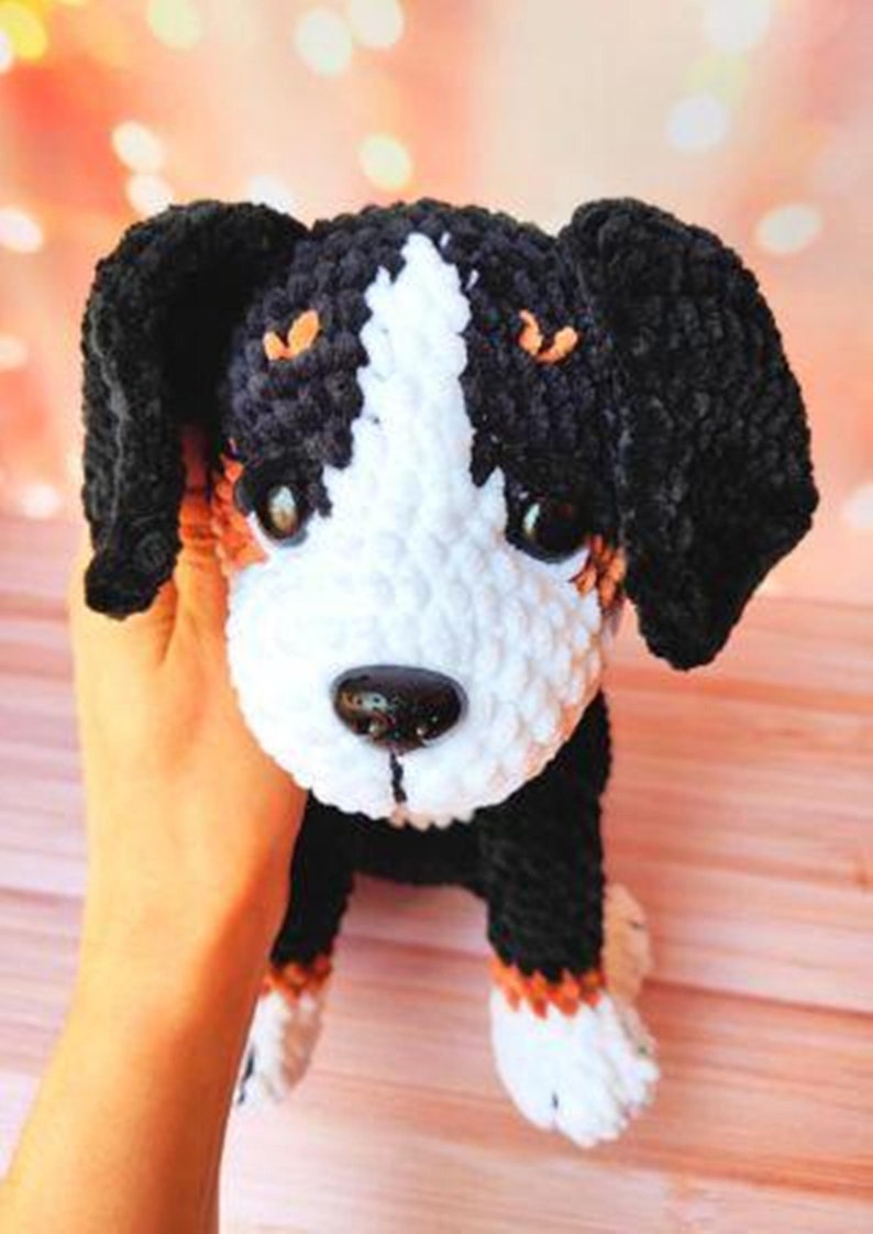 K&ouml;nnte beinhalten: Ein geh&auml;keltes Stofftier in Form eines Hundes mit schwarzem, wei&szlig;em und braunem Fell. Der Hund hat ein wei&szlig;es Gesicht mit schwarzen Augen und einer schwarzen Nase.