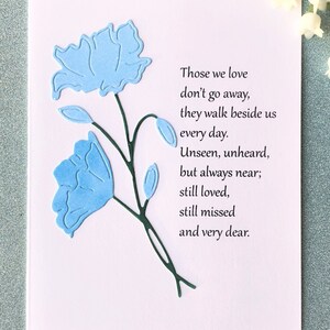 May include: A sympathy card with a blue floral design and the text "Those we love don't go away, they walk beside us every day. Unseen, unheard, but always near; still loved, still missed and very dear."
