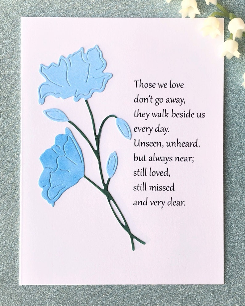 May include: A sympathy card with a blue floral design and the text "Those we love don't go away, they walk beside us every day. Unseen, unheard, but always near; still loved, still missed and very dear."