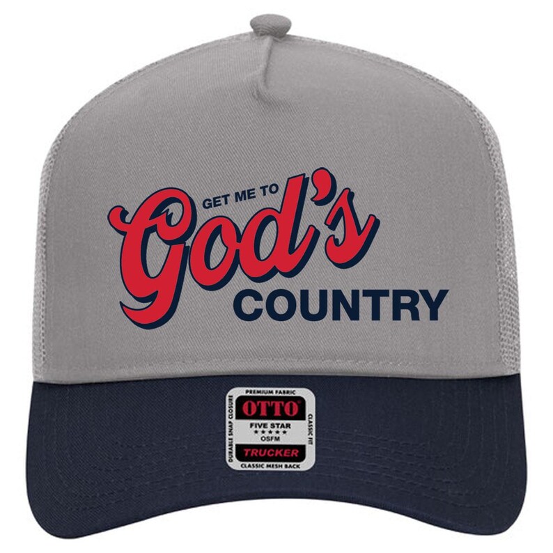 May include: Gray and navy blue trucker hat with the text "Get Me To God's Country" in red script. The hat features a mesh back and a snap closure. The brand name "OTTO" is visible on a small tag.