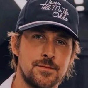 May include: A black baseball cap with a white brim and the text "Never Tell Me The Odds" embroidered in white on the front.