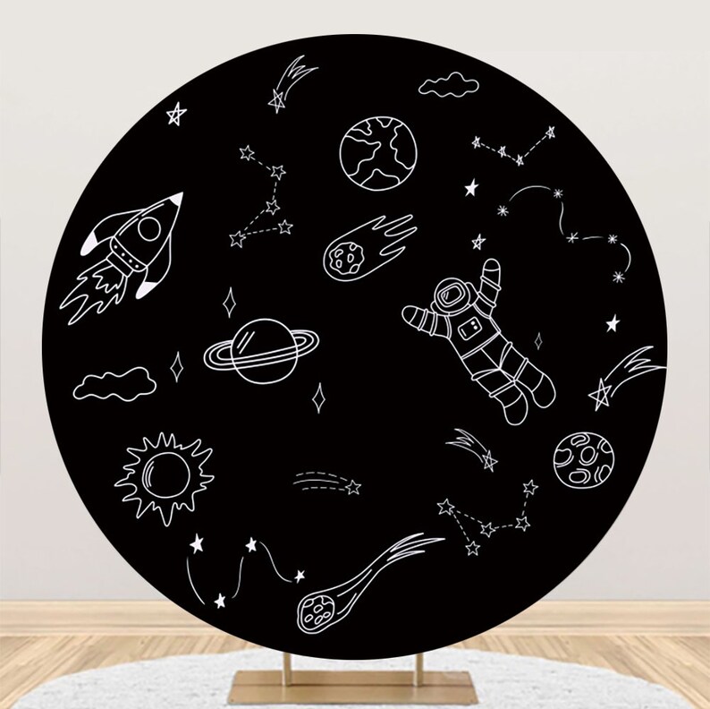 Op de afbeelding: Zwarte en witte ronde achtergrond met een astronaut, een raket, sterren, planeten en een komeet. De achtergrond is perfect voor een ruimtethemafeest of fotoshoot.