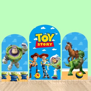 May include: Three blue and white cardboard cutouts featuring characters from the movie Toy Story. The center cutout features the text "Toy Story" in white letters. The left cutout features Buzz Lightyear, a space ranger toy, flying in the air. The right cutout features Woody, a cowboy toy, and Rex, a dinosaur toy.
