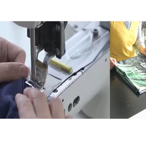 May include: Close-up of a sewing machine needle stitching a dark blue fabric. The fabric is being held in place by a hand. In the background, a person is folding a green and white fabric with a tropical leaf pattern.