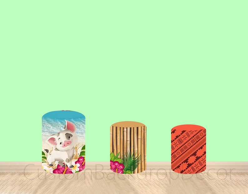 May include: Three cylindrical party decorations with different designs. The first is a light blue cylinder with a cartoon pig and flowers. The second is a brown cylinder with a bamboo pattern and green leaves. The third is a red cylinder with a geometric pattern.