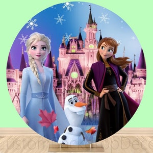 Puede incluir: Un tel&oacute;n de fondo redondo con un castillo rosa con dos princesas de la pel&iacute;cula Frozen. Elsa lleva un vestido azul claro y Anna lleva un vestido morado y negro. Olaf el mu&ntilde;eco de nieve est&aacute; de pie frente al castillo.