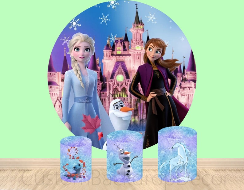 Puede incluir: Tres soportes redondos de tela de fondo, de color morado y azul, con im&aacute;genes de personajes de la pel&iacute;cula Frozen. Los soportes presentan un caballo azul y blanco, un mu&ntilde;eco de nieve y un lagarto.