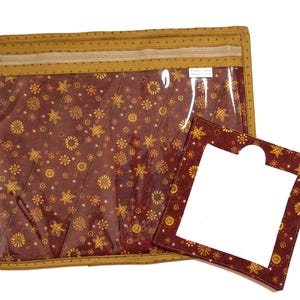 May include: A rectangular zippered storage pouch with a clear plastic front and a dark red fabric backing featuring a yellow sun and star pattern, accompanied by a smaller square fabric frame with a matching sun and star print design.