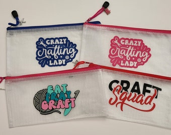 May include: Four clear mesh zipper pouches with colorful designs. One pouch has "CRAZY Crafting LADY" in blue, another in pink. The third says "EAT PRAY CRAFT" and the last says "CRAFT Squad".