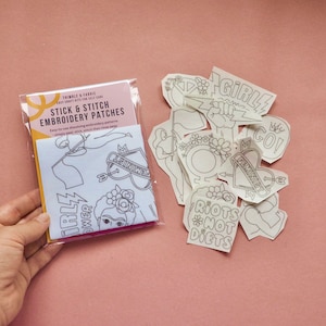 May include: A package of stick and stitch embroidery patches with various designs, including text that reads "Girl Power" and "Feminist". The patches are white with black outlines and are designed for easy self-care crafting.