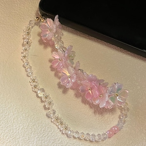 ピンクがかった桜の花とパールの携帯ストラップ