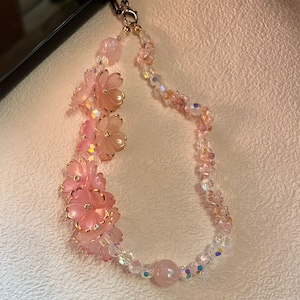 Correa para teléfono con flores de cerezo rosa y perlas