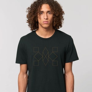 Könnte beinhalten: Ein schwarzes T-Shirt mit einem goldenen geometrischen Design auf der Vorderseite. Das Design besteht aus Quadraten und Diamanten.