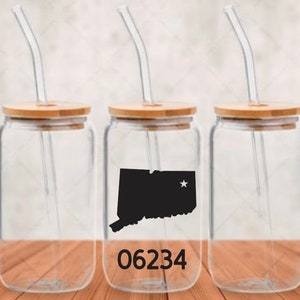 May include: Clear glass beverage cups with bamboo lids and curved glass straws. One cup features a black silhouette of the state of Connecticut with a star and the number "06234" in black. The other two cups are plain.