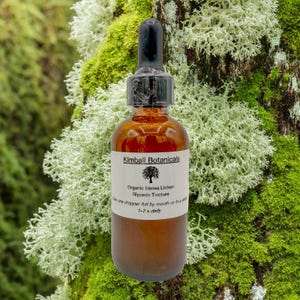 May include: A brown glass bottle with a black dropper, labeled "Kimball Botanicals." The label reads "Organic Usnea Lichen Glycerin Tincture." The bottle is set against a backdrop of green and white moss.