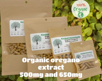 May include: Several brown paper bags of organic oregano extract capsules are displayed against a green leafy background. The bags have white labels with a tree logo and the text "Kimball Botanicals." The text "Organic oregano extract 500mg and 650mg" is also visible.