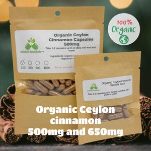 May include: Two brown paper bags containing organic Ceylon cinnamon capsules. The larger bag contains 500mg capsules and the smaller bag contains a sample pack of capsules. Both bags have a label with the brand name Kimball Botanicals and instructions for use. The larger bag also has a label that says "100% Organic".