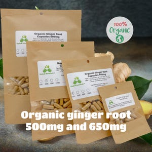 May include: Three brown paper pouches containing organic ginger root capsules. The pouches are labeled with the text "Organic Ginger Root Capsules 500mg" and "Organic Ginger Root Capsules 650mg". The pouches are arranged in a row from largest to smallest. The text "100% Organic" is visible in the top right corner of the image.