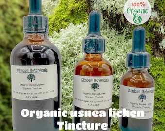 May include: Three brown glass bottles of organic usnea lichen glycerin tincture with blue droppers. Each bottle has a white label with the Kimball Botanicals logo and text. The text "Organic usnea lichen Tincture" is displayed at the bottom.