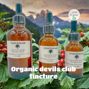 May include: Three amber glass bottles with droppers, labeled "Kimball Botanicals" and "Organic Devil's Club Bark Flax Glycerin Tincture." The bottles are filled with a brown liquid. The text "Organic devils club tincture" is at the bottom.