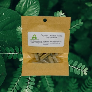 May include: A small brown paper bag with a label that reads "Organic Chanca Piedra Sample Pack". The bag contains a sample pack of capsules. The label also includes instructions for taking the capsules.