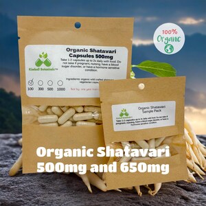 May include: Two brown paper bags with white text and a green leaf logo. The larger bag contains a bottle of organic Shatavari capsules, 500mg. The smaller bag contains a sample pack of organic Shatavari capsules. The text on the bags reads "100% Organic" and "Organic Shatavari Capsules 500mg".