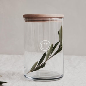Nachhaltiges Vorratsglas mit Holzdeckel aus Buche und weißem Smiley auf dem Glas. Dankesbotschaft und Möglichkeit zur Personalisierung auf dem Deckel.