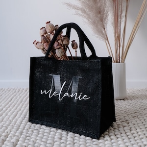 mit Dekoration gefüllte Jute Einkaufstasche in schwarz mit Monogramm und Namen. Ideal als Geschenk