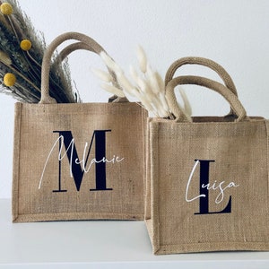 Personalisierte naturbraune Jutetaschen mit Monogramm und Namen gefüllt mit Dekoration