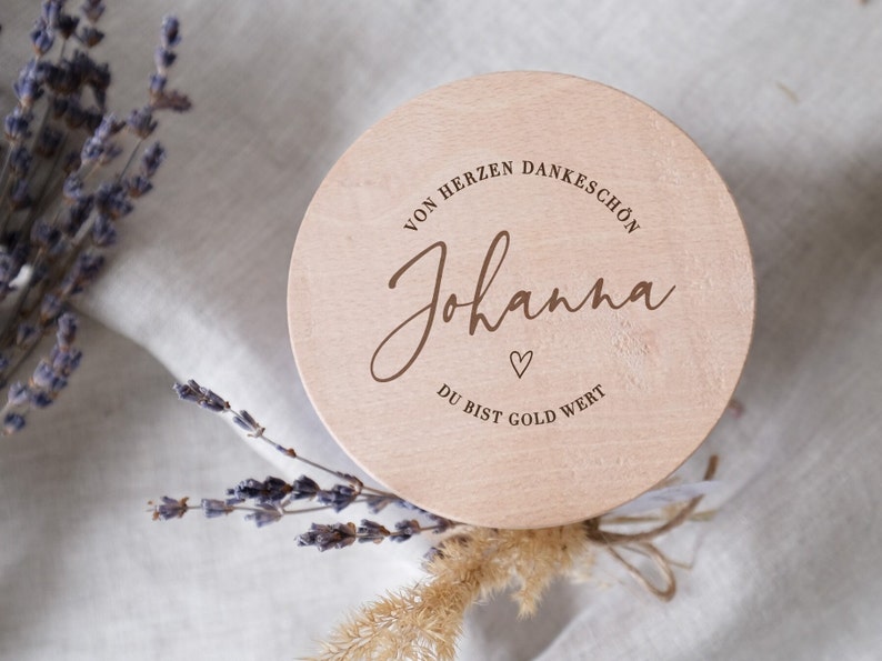 Personalisierte Holzbox als Geschenkverpackung mit der Aufschrift "Von Herzen Dankeschön - Du bist Gold wert". Diese einzigartige, liebevoll gestaltete Box eignet sich perfekt, um Wertschätzung und Dankbarkeit auszudrücken. Ideal für besondere Anlässe, schafft sie unvergessliche Momente und berührt das Herz des Beschenkten. Ein emotionales und stilvolles Präsent, das in Erinnerung bleibt.