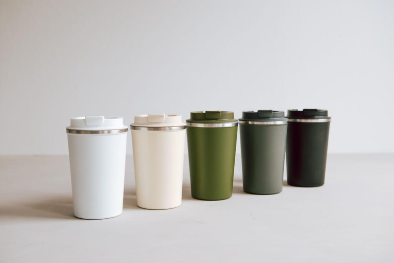 Stilvolle, umweltfreundliche Thermobecher in sanften Naturtönen stehen in einer eleganten Reihe. Perfekt für Ihren täglichen Kaffee oder Tee unterwegs. Genießen Sie jede Schluck mit modernem Design und halten Sie Ihr Getränk stundenlang heiß oder kalt. Diese Becher vereinen Funktionalität mit Ästhetik und sind ein Muss für jeden umweltbewussten Lifestyle-Liebhaber.