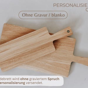 K&ouml;nnte beinhalten: Zwei Holzschneidebretter mit Griffen, eines auf dem anderen. Die Bretter sind hellbraun mit sichtbarer Holzmaserung. Der Text "Ohne Gravur / blanko" ist sichtbar. Der Text "PERSONALISIERUNGS-OPTION:" ist ebenfalls sichtbar.