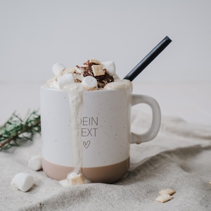 Gravierte Keramiktasse mit rustikalem Design – Tasse mit weißer matter Lasur und kleinen sprenkeln der Oberfläche und unglasiertem Bodendesign in Natur, individuell anpassbar nach euren wünschen. Gefüllt mit Marshmallows und Keksen