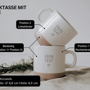 May include: Two white ceramic mugs with a speckled finish and a light brown base are stacked. Each mug has a handle and the text "DEIN TEXT" with a heart symbol. The mugs are 3.5 inches in diameter and 3.5 inches high.