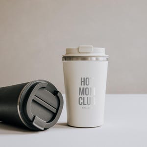 Moderner Thermobecher aus Edelstahl mit der Aufschrift "Hot Mom Club" in stilvollem Design. Perfekt für unterwegs, hält Getränke heiß und verleiht jedem Tag einen Hauch von Eleganz. Das minimalistische Design und die hochwertige Verarbeitung machen ihn zum idealen Begleiter für stilbewusste Mütter. Nachhaltig, praktisch und ein echter Hingucker.