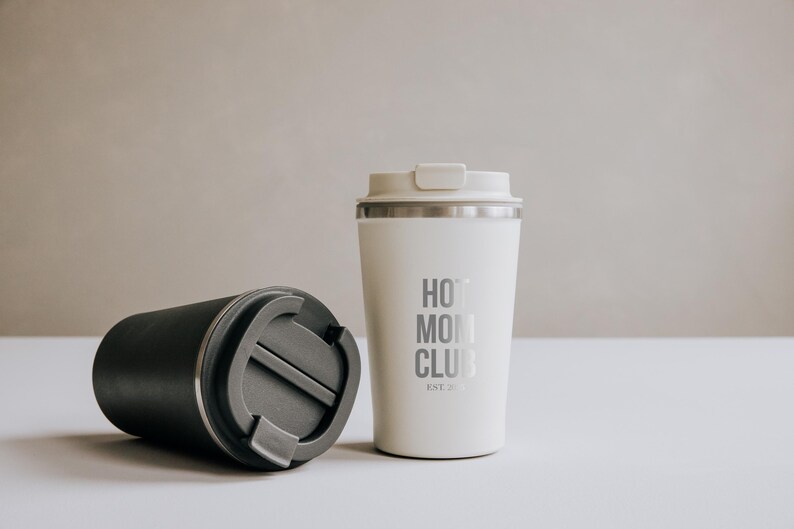 Moderner Thermobecher aus Edelstahl mit der Aufschrift "Hot Mom Club" in stilvollem Design. Perfekt für unterwegs, hält Getränke heiß und verleiht jedem Tag einen Hauch von Eleganz. Das minimalistische Design und die hochwertige Verarbeitung machen ihn zum idealen Begleiter für stilbewusste Mütter. Nachhaltig, praktisch und ein echter Hingucker.