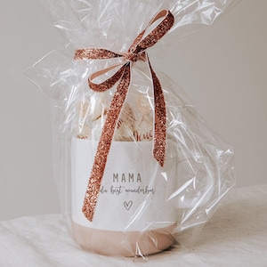 Gravierte Keramiktasse eingepackt als Geschenk mit Folie und gefüllt mit Pralinen. Geschenk für den Lieblingsmenschen. Mama Papa du bist wunderbar