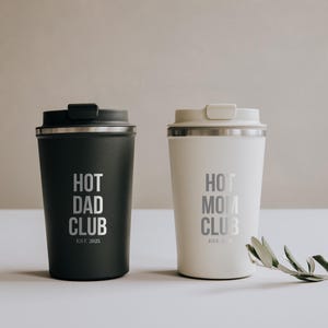 Zwei stilvolle Thermobecher mit der Aufschrift "Hot Dad Club" und "Hot Mom Club" in elegantem Schwarz und Weiß. Perfekt für Eltern, die ihren Kaffee unterwegs genießen möchten und dabei ein Statement setzen wollen. Diese Becher vereinen Funktionalität und Design und sind ein ideales Geschenk, das sowohl praktisch als auch modisch ist. Ein Must-Have für trendbewusste Eltern.