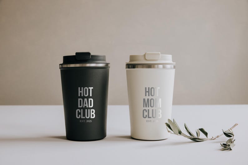 Zwei stilvolle Thermobecher mit der Aufschrift "Hot Dad Club" und "Hot Mom Club" in elegantem Schwarz und Weiß. Perfekt für Eltern, die ihren Kaffee unterwegs genießen möchten und dabei ein Statement setzen wollen. Diese Becher vereinen Funktionalität und Design und sind ein ideales Geschenk, das sowohl praktisch als auch modisch ist. Ein Must-Have für trendbewusste Eltern.