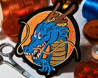 May include: An embroidered patch featuring a blue and gold dragon with a yellow background. The dragon has a fierce expression and is surrounded by a gold swirl.