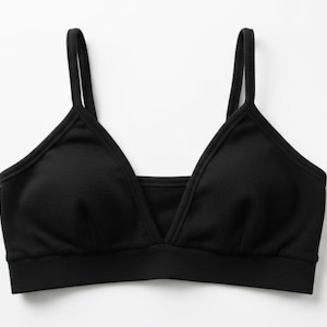 May include: A black bralette with a V-neck design and thin shoulder straps. The bra has a simple, minimalist style and is made of a soft, comfortable material. The bralette is a versatile piece for everyday wear.