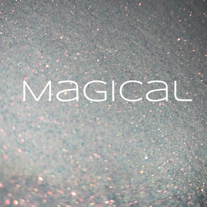 May include: A close-up of iridescent glitter with the word "Magical" written in white text.