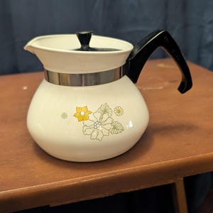 May include: A handmade, wooden serving tray with a natural finish. The tray features a rectangular shape with raised edges and integrated handles. The wood grain is visible, showcasing the tray's craftsmanship. Dimensions: 18 inches long, 12 inches wide, and 2 inches high.