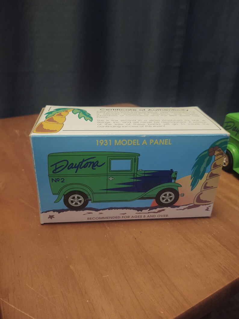 Puede incluir: Un coche de juguete verde y azul 1931 Model A Panel Daytona No. 2 sobre un fondo blanco. La caja tiene una palmera y el texto "Recomendado para mayores de 8 a&ntilde;os."