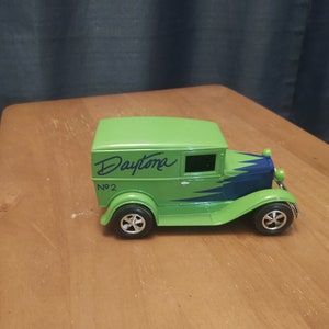 Puede incluir: Modelo de juguete verde de un cami&oacute;n de reparto vintage con detalles azules y blancos. El cami&oacute;n tiene la palabra "Daytona" escrita en el lateral y el n&uacute;mero "No. 2" debajo.