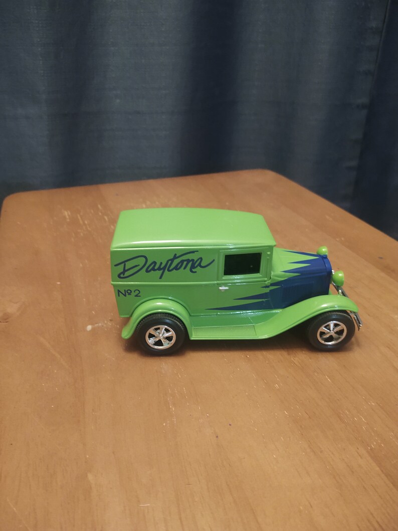 Puede incluir: Modelo de juguete verde de un cami&oacute;n de reparto vintage con detalles azules y blancos. El cami&oacute;n tiene la palabra "Daytona" escrita en el lateral y el n&uacute;mero "No. 2" debajo.
