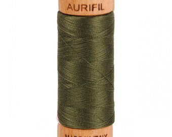 May include: A spool of dark green thread with the brand name "Aurifil" printed on the wooden spool. The spool also has the text "Made in Italy" printed on the bottom.