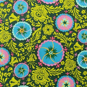 May include: A green fabric with a repeating pattern of blue, pink, and yellow flowers. The flowers have a star-shaped center and are surrounded by green leaves and swirls.